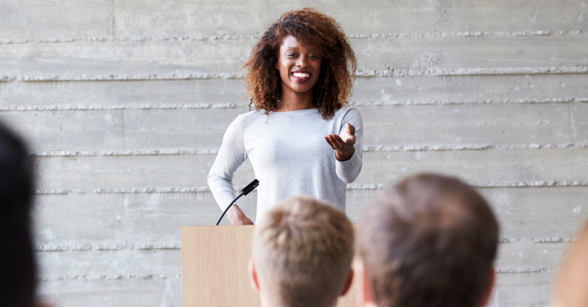 13931-woman-public-speaking-at-podium-with-micropho